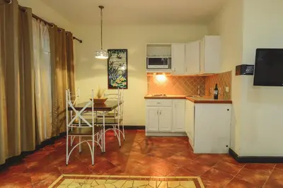 a kitchen with a table and a small kitchen with a table and chairs at Hotel Luisiana in San José