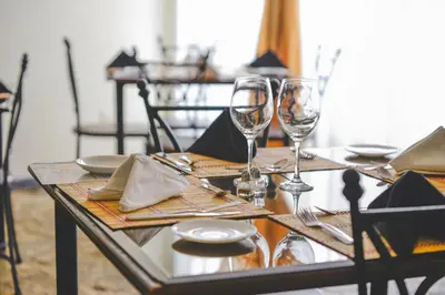 a dining table with wine glasses and plates on it at Hotel Luisiana in San José