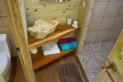 a small bathroom with a sink and a toilet at Forest Lodge in Uvita