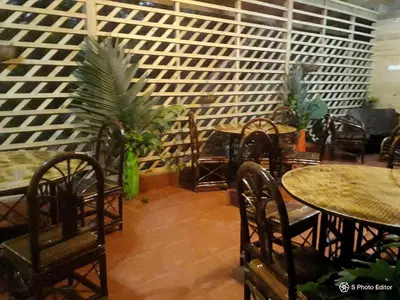 a dining room with tables and chairs and plants at Forest Lodge in Uvita