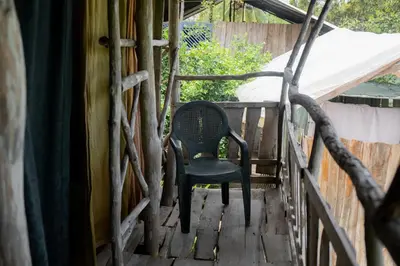 a black chair sitting on a wooden porch at Miguel Surf Camp in Quepos