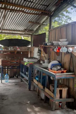 a kitchen with a table with pots and pans at Miguel Surf Camp in Quepos