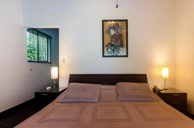 a bedroom with a large bed with two nightstands and two lamps at Casa Gris with private pool near the beach in Jaco in Jacó