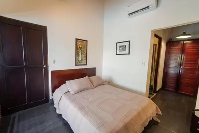 a bedroom with a bed in a room at Casa Gris with private pool near the beach in Jaco in Jacó