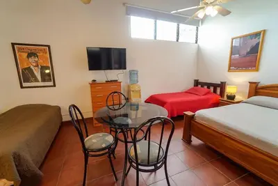 a bedroom with a bed and a table and chairs at Casa Gris with private pool near the beach in Jaco in Jacó