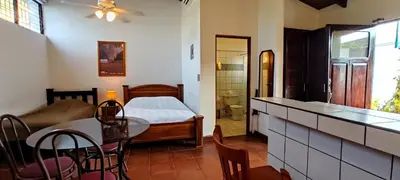 a living room with a bed and a table and chairs at Casa Gris with private pool near the beach in Jaco in Jacó