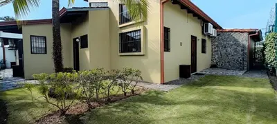 a house with a grass yard in front of it at Casa Gris with private pool near the beach in Jaco in Jacó