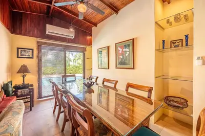 a dining room with a glass table and chairs at Casa Mandolina on the beach in Jaco in Jacó