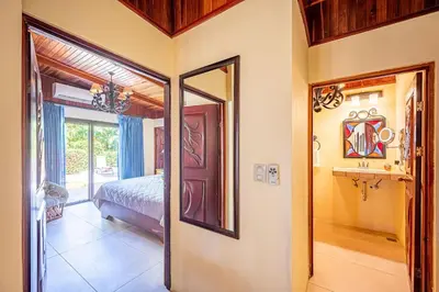 a bedroom with a bed and a mirror in a room at Casa Mandolina on the beach in Jaco in Jacó