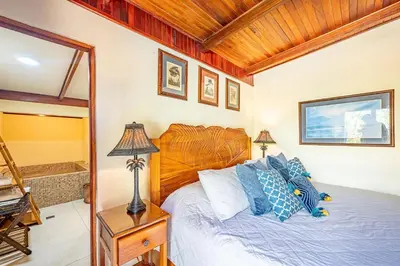a bedroom with a bed with blue pillows at Casa Mandolina on the beach in Jaco in Jacó