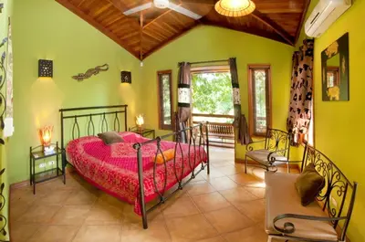 a bedroom with a red bed in a room at Quinta Teca with two pools near Playa Hermosa beach in Playa Hermosa