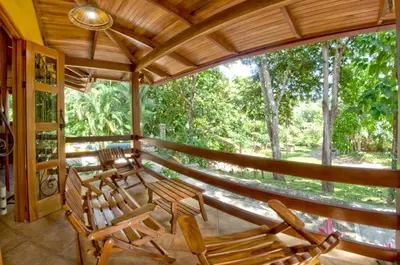 a porch with rocking chairs and a large window at Quinta Teca with two pools near Playa Hermosa beach in Playa Hermosa