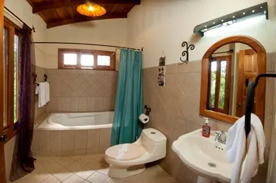 a bathroom with a tub and a toilet and a sink at Quinta Teca with two pools near Playa Hermosa beach in Playa Hermosa