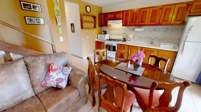 a living room with a couch and a table and a kitchen at Rio Copey 2 townhouse near the beach in Jaco in Jacó