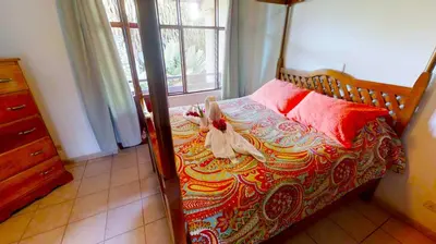 a bedroom with a bed with a stuffed animal on it at Rio Copey 2 townhouse near the beach in Jaco in Jacó