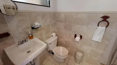 a bathroom with a white toilet and a sink at Rio Copey 2 townhouse near the beach in Jaco in Jacó
