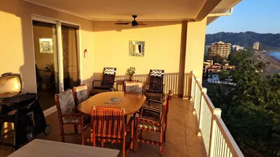 a porch with a table and chairs on a balcony at The Palms Jaco 1001 penthouse on the beach in Jacó