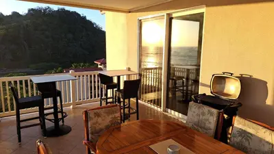 a balcony with a table and chairs and a tv at The Palms Jaco 1001 penthouse on the beach in Jacó