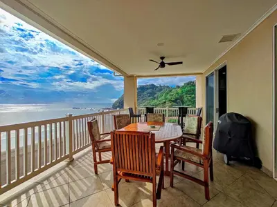 a balcony with a table and chairs and a view of the ocean at The Palms Jaco 1001 penthouse on the beach in Jacó
