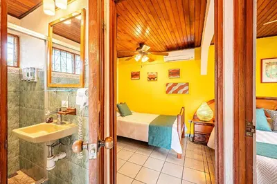 a bathroom with a bed and a shower and a sink at Villa Jaco Sol 4 bdr resort pool near the beach in Jacó