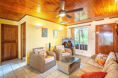 a living room with couches and a ceiling fan at Villa Jaco Sol 4 bdr resort pool near the beach in Jacó