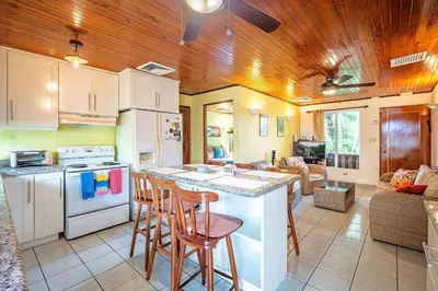 a kitchen with a counter and chairs in a room at Villa Jaco Sol 4 bdr resort pool near the beach in Jacó