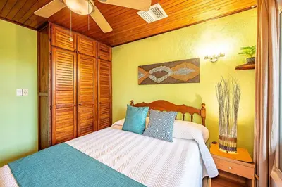 a bedroom with a bed and a ceiling fan at Villa Jaco Sol 4 bdr resort pool near the beach in Jacó