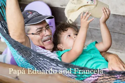 a man and a child sitting in a hammock at Eco Guest House - Sarapiquí 1 in Sarapiquí