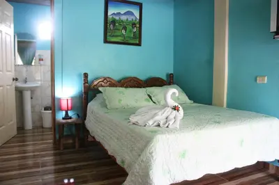 a bedroom with a bed with a swan on it at Cabinas Cascada Rio Celeste in Bijagua