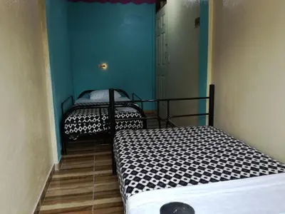 two twin beds in a room with blue walls at Cabinas Cascada Rio Celeste in Bijagua