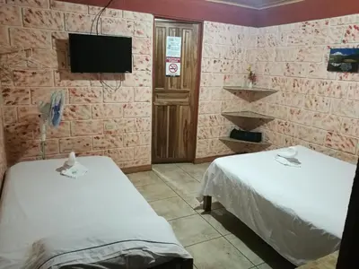 a hospital room with two beds and a tv at Hospedaje Las Orquídeas in Venecia
