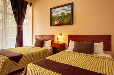 a hotel room with two beds and a window at Hotel Las Colinas in Fortuna