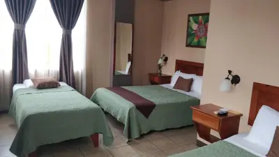 a hotel room with two beds and a window at Hotel Las Colinas in Fortuna