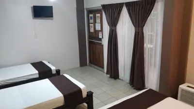 a hotel room with two beds and a window at Hotel Las Colinas in Fortuna
