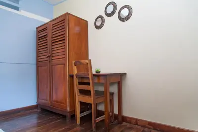 a wooden desk with a chair next to a cabinet at Hotel Brasilito in Brasilito