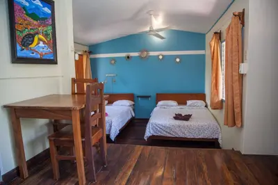 a bedroom with a bed and a desk and a table at Hotel Brasilito in Brasilito