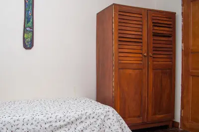 a bedroom with a wooden cabinet next to a bed at Hotel Brasilito in Brasilito