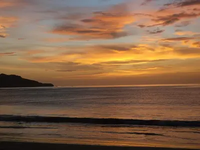 a sunset on a beach with the ocean at Hotel Brasilito in Brasilito