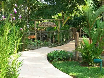 a garden with a gate with a sign and plants at Blue River Resort & Hot Springs in Liberia