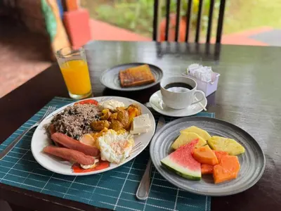 a table with two plates of food and a cup of coffee at Blue River Resort & Hot Springs in Liberia