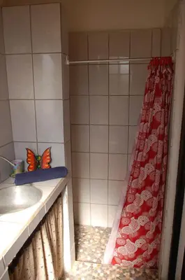 a bathroom with a shower with a butterfly on the curtain at Casa bungalow Ital-Tico in Paraíso