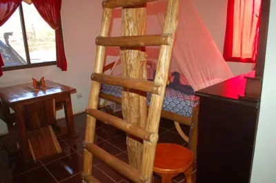 a wooden ladder in a room with a bed at Casa bungalow Ital-Tico in Paraíso