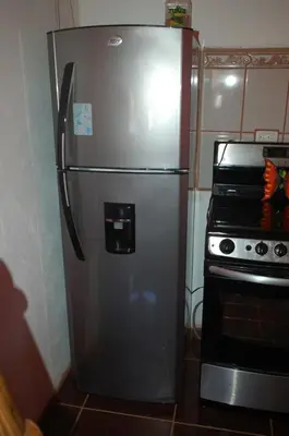 a stainless steel refrigerator in a kitchen next to an oven at Casa bungalow Ital-Tico in Paraíso