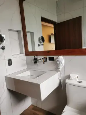 a bathroom with a white sink and a phone at Hotel Mi Linda Tierra in Quesada