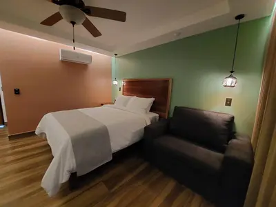 a hotel room with a bed and a couch at Hotel Mi Linda Tierra in Quesada
