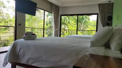 a bedroom with two beds and a large window at Hotel Mi Linda Tierra in Quesada