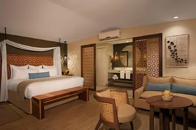 a bedroom with a bed and a living room at Secrets Papagayo All Inclusive - Adults Only in Papagayo, Guanacaste