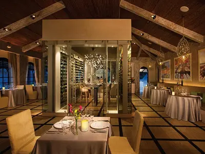 a dining room with tables and chairs and a wine cellar at Secrets Papagayo All Inclusive - Adults Only in Papagayo, Guanacaste