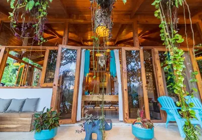 a room with potted plants and a blue chair at Villas Wanderlust in Puntarenas