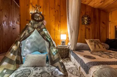 a bedroom with two beds in a room with wooden walls at Villas Wanderlust in Puntarenas